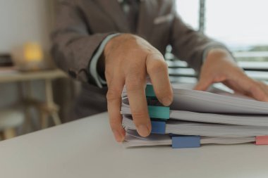 Bir ofis çalışanı her şeyi güvende tutmak için önemli belgeleri bir araya getiriyor. Bir iş adamı önemli iş belgelerini düzgün bir yere koyuyor. Belgeler ve raporlar.