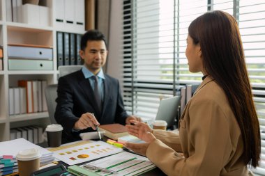 Ofiste birlikte yeni bir proje üzerinde çalışıyorlar. Masada bir grup işadamının çalışması gereken bir sürü evrak işi var. İş toplantısı, işyeri, iş adamları.