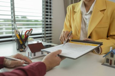 Bir adam bir menajerle ev almayı kabul ettikten sonra bir sözleşme imzalar. Temsilci imzalamadan önce sözleşmenin detaylarını alıcıya açıklar. Ev satın alma sözleşmesi