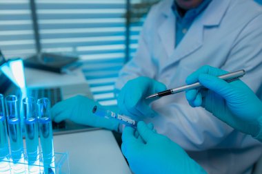 Laboratuvarda mikroskop, test tüpü, bilimsel sıvılar gibi bir sürü bilimsel ekipman var. İki bilim adamı laboratuvar araştırmalarında yeni bir ilaç formülü üzerinde çalışıyorlar.