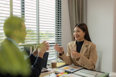 Ofiste birlikte yeni bir proje üzerinde çalışıyorlar. Masada bir grup işadamının çalışması gereken bir sürü evrak işi var. İş toplantısı, işyeri, iş adamları.