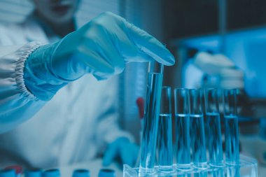 Bir kimyager laboratuvarda bir sıvı örneğini inceler, bilimsel deney ekipmanları, mikroskop, kadın bilim adamı, kadın kimyager ve araştırmacı bilimsel araştırmalar yapar.