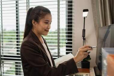 Ofiste çalışan bir mimar, işyerinde çalışan bir mühendis, plan ve ev modeli, çeşitli iş ekipmanlarıyla dolu bir mimarlık bürosu.