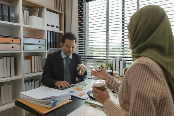 Bir grup iş adamı bir ofiste tartışıyorlar. Farklı kültürlerden iş adamları uygun ve dini açıdan doğru ürünler üretmek için toplanıyorlar. Bir iş kadını başörtüsü takıyor..