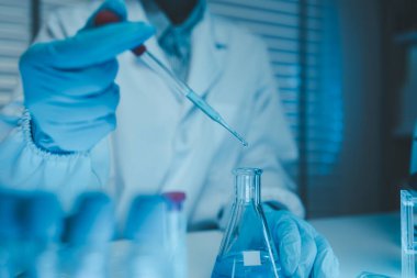 Bir kimyager laboratuvarda bir sıvı örneğini inceler, bilimsel deney ekipmanları, mikroskop, kadın bilim adamı, kadın kimyager ve araştırmacı bilimsel araştırmalar yapar.