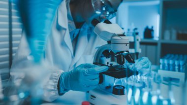 Bir kimyager laboratuvarda bir sıvı örneğini inceler, bilimsel deney ekipmanları, mikroskop, kadın bilim adamı, kadın kimyager ve araştırmacı bilimsel araştırmalar yapar.