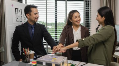 Bir grup mimar, iş başarıyla tamamlandıktan sonra birbirlerini tebrik ediyor. Bir mimarlık firmasının kurucuları, bir inşaat anlaşmasını başarıyla sonuçlandırdıktan sonra kutlama yapıyorlar.