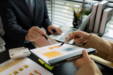 Ofiste birlikte yeni bir proje üzerinde çalışıyorlar. Masada bir grup işadamının çalışması gereken bir sürü evrak işi var. İş toplantısı, işyeri, iş adamları.