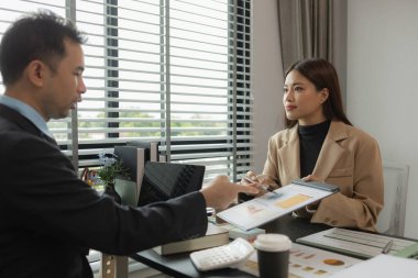 Ofiste birlikte yeni bir proje üzerinde çalışıyorlar. Masada bir grup işadamının çalışması gereken bir sürü evrak işi var. İş toplantısı, işyeri, iş adamları.