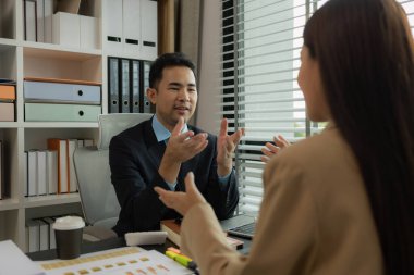 Ofiste birlikte yeni bir proje üzerinde çalışıyorlar. Masada bir grup işadamının çalışması gereken bir sürü evrak işi var. İş toplantısı, işyeri, iş adamları.