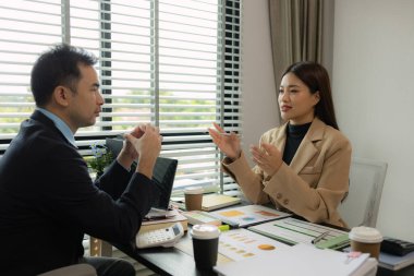 Ofiste birlikte yeni bir proje üzerinde çalışıyorlar. Masada bir grup işadamının çalışması gereken bir sürü evrak işi var. İş toplantısı, işyeri, iş adamları.