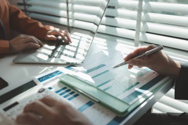 Çalışanlar, iş bitmeden önce tamamlanması gereken bir yığın belgeyle bir ofiste otururken, girişimciler yatırımcılara sunum hazırlamak için işlerini planlıyorlar.