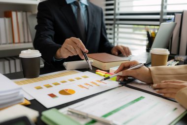 Ofiste birlikte yeni bir proje üzerinde çalışıyorlar. Masada bir grup işadamının çalışması gereken bir sürü evrak işi var. İş toplantısı, işyeri, iş adamları.