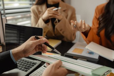 Bir grup çalışan, şirketin ürünlerinin satışını arttırmak için beyin fırtınası yapıyor iş adamları sunumlarını, takım çalışmalarını, beyin fırtınalarını, şirket çalışmalarını geliştirmeye çalışıyorlar.