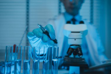 Laboratuvar, modern laboratuvarda bilimsel ekipman üzerinde çalışan bilim adamı, tıbbi laboratuvarda birlikte çalışan uluslararası bilim adamları, kimyasallar ve bakteriler üzerine araştırma yapıyorlar.