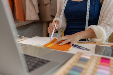 Atölyede dikiş malzemeleri kullanan kadın moda tasarımcısı, kumaş atölyesinde çalışan genç bir kadının portresi, atölyesinde çalışan genç bir terzi manzarası.