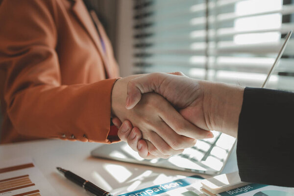 business partners shake hands after successfully signing a joint venture agreement, Successful partnership, Cheerful businesspeople shaking hands in meeting room, company, teamwork