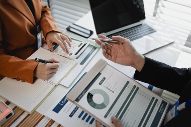 Ofis çalışanları bir şirkette birlikte çalışıyor, işadamları oturmuş ortak projeleri hakkında görüşüyor, iki çalışan ofiste beyin fırtınası yapıyor, masada bir sürü evrak işi var.