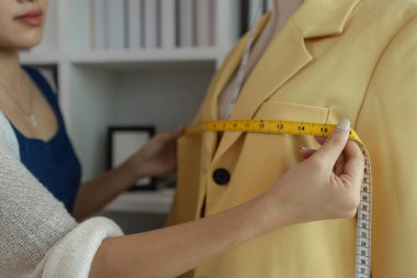 Kumaş üzerine profesyonel işaretleme, stüdyoda çalışan tasarımcı, atölyede manken üzerine giysi tasarımı ayarlayan tasarımcı, moda atölyesinde kumaşı ölçen kadın.