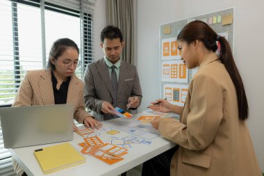 Web tasarım ekibi, günümüz kullanıcıları için uygun, modern ve kullanıcı dostu dijital ürünlerin nasıl geliştirileceği konusunda fikir alışverişinde bulunuyor.