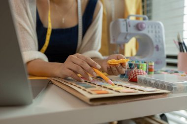 Kumaş üzerine profesyonel işaretleme, stüdyoda çalışan tasarımcı, atölyede manken üzerine giysi tasarımı ayarlayan tasarımcı, moda atölyesinde kumaşı ölçen kadın.