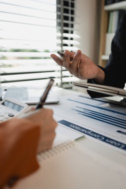 Ofis çalışanları bir şirkette birlikte çalışıyor, işadamları oturmuş ortak projeleri hakkında görüşüyor, iki çalışan ofiste beyin fırtınası yapıyor, masada bir sürü evrak işi var.