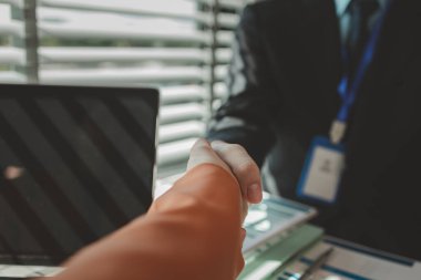 İş ortakları ortak bir girişim anlaşmasını başarıyla imzaladıktan sonra el sıkışırlar, başarılı bir ortaklık, neşeli iş adamları toplantı odasında, şirkette, takım çalışmasında el sıkışırlar.