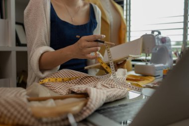 Kumaş üzerine profesyonel işaretleme, stüdyoda çalışan tasarımcı, atölyede manken üzerine giysi tasarımı ayarlayan tasarımcı, moda atölyesinde kumaşı ölçen kadın.