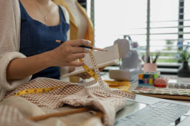 Kumaş üzerine profesyonel işaretleme, stüdyoda çalışan tasarımcı, atölyede manken üzerine giysi tasarımı ayarlayan tasarımcı, moda atölyesinde kumaşı ölçen kadın.