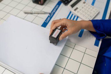 Çalışanların sağladığı belgeleri imzala ve onayla, bir iş kadını ofisinde oturup çeşitli satın alma emirleri imzalarken, finans departmanı