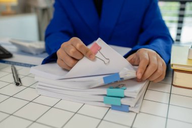 Özel ofiste çalışan bir çalışan, masadaki bir sürü belgeyle uğraşan, iş hayatı, pazarlama ve finans departmanı, ofisinde çalışan bir girişimci.