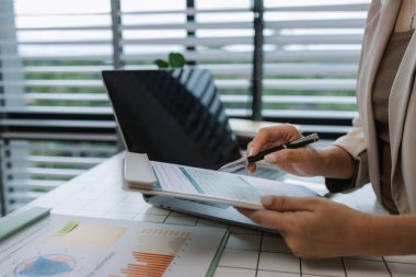 İş yerindeki iş kadınlarıyla evrak işleri, bilgisayar, veri ve belgelerle ilgili raporlar ve raporlar. Rapor üzerinde çalışan kadın personel ya da internet evrakları üzerinde çalışan işadamı