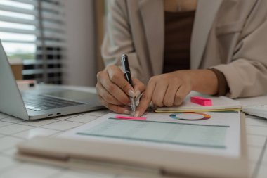 İş yerindeki iş kadınlarıyla evrak işleri, bilgisayar, veri ve belgelerle ilgili raporlar ve raporlar. Rapor üzerinde çalışan kadın personel ya da internet evrakları üzerinde çalışan işadamı