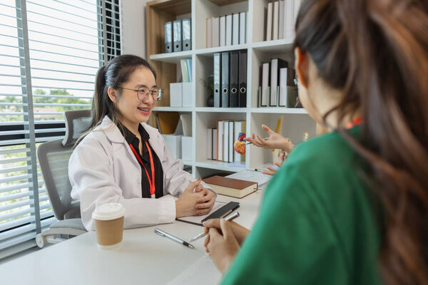 the three doctors are meeting to exchange new knowledge and information they have gained form their medical seminars with each other, a senior doctor is explaining information and knowledge