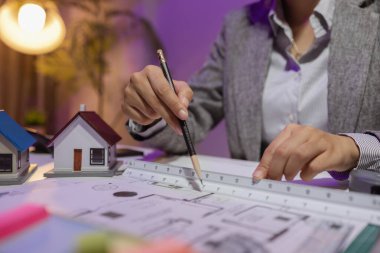 Güzel bir kadın mimar özel ofisinde çalışıyor çünkü kanunlara, mühendislere, ustabaşına ve müteahhitlere uygun olması için planların geliştirilmesine konsantre olması gerekiyor.