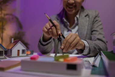 Güzel bir kadın mimar özel ofisinde çalışıyor çünkü kanunlara, mühendislere, ustabaşına ve müteahhitlere uygun olması için planların geliştirilmesine konsantre olması gerekiyor.