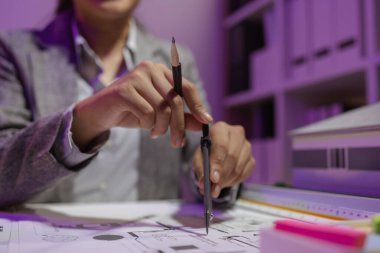 Güzel bir kadın mimar özel ofisinde çalışıyor çünkü kanunlara, mühendislere, ustabaşına ve müteahhitlere uygun olması için planların geliştirilmesine konsantre olması gerekiyor.