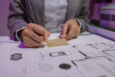 Güzel bir kadın mimar özel ofisinde çalışıyor çünkü kanunlara, mühendislere, ustabaşına ve müteahhitlere uygun olması için planların geliştirilmesine konsantre olması gerekiyor.