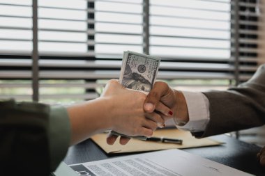 Avukat ve müvekkil yasadışı anlaşmalar için rüşvet aldıktan sonra el sıkışıyor, bir davayı kazanmak için karşı avukata rüşvet veriyor, yolsuzluk ve rüşvet yasadışı