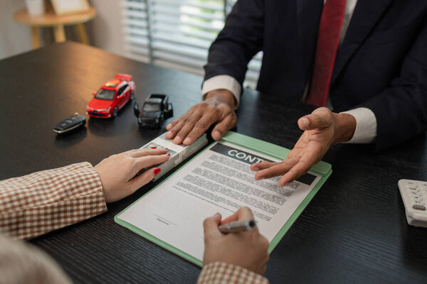 продавец автомобиля разъясняет покупателю детали договора купли-продажи автомобиля до подписания договора купли-продажи, выставочного зала, дилера, автомобильного контракта, подписания договора купли-продажи автомобиля