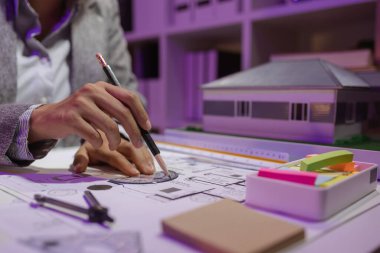 Güzel bir kadın mimar özel ofisinde çalışıyor çünkü kanunlara, mühendislere, ustabaşına ve müteahhitlere uygun olması için planların geliştirilmesine konsantre olması gerekiyor.