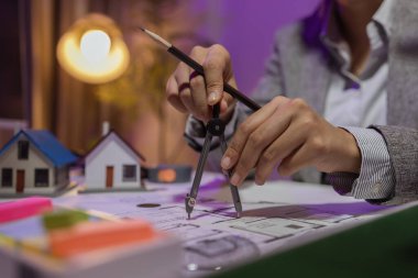 Güzel bir kadın mimar özel ofisinde çalışıyor çünkü kanunlara, mühendislere, ustabaşına ve müteahhitlere uygun olması için planların geliştirilmesine konsantre olması gerekiyor.