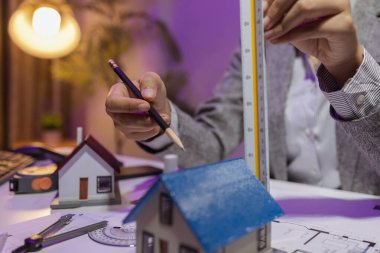 Tecrübeli bir kadın mühendis, özel ofisindeki bir ev modeline son bir çek veriyor. Planlara uyduğundan ve inşaatın bitiş tarihine yetiştiğinden emin olmak için.