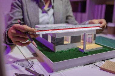 Tutkulu bir kadın mimar, müşterisinin tam ihtiyaçlarını karşılamak ve inşaat tarihlerini, ev modelini, mühendisini, planlarını karşılamak için bir evi yeniden düzenlemek için özel ofisinde çalışır.