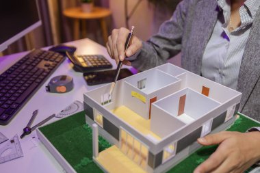 Tutkulu bir kadın mimar, müşterisinin tam ihtiyaçlarını karşılamak ve inşaat tarihlerini, ev modelini, mühendisini, planlarını karşılamak için bir evi yeniden düzenlemek için özel ofisinde çalışır.