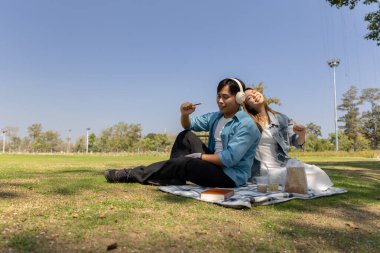 Bir çift bahçede piknik yapıyor. Eğer hava güzel olduğunda, çift birlikte mutlu vakit geçiriyorsa, Sevgililer Günü 'nde birlikte vakit geçirmekten zevk alıyorlarsa.