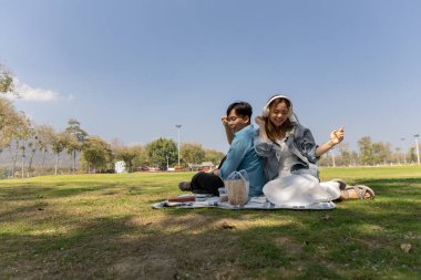 Bir çift bahçede piknik yapıyor. Eğer hava güzel olduğunda, çift birlikte mutlu vakit geçiriyorsa, Sevgililer Günü 'nde birlikte vakit geçirmekten zevk alıyorlarsa.