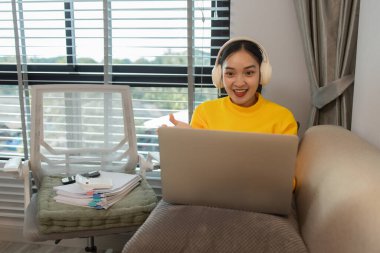 Bir kadın tatilini evinin oturma odasında, huzurlu ve mutlu bir şekilde geçirir çünkü kendisini rahat, yaşam tarzı, dairesi, kanepesi, koltuğu, kanepede hissettiren birçok etkinlik yapmıştır.