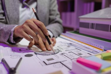 Güzel bir kadın mimar özel ofisinde çalışıyor çünkü kanunlara, mühendislere, ustabaşına ve müteahhitlere uygun olması için planların geliştirilmesine konsantre olması gerekiyor.