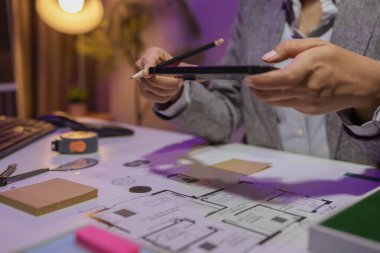 Güzel bir kadın mimar özel ofisinde çalışıyor çünkü kanunlara, mühendislere, ustabaşına ve müteahhitlere uygun olması için planların geliştirilmesine konsantre olması gerekiyor.